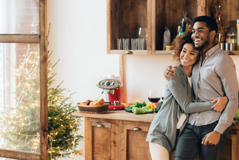 oung loving couple embrace in the kitchen as they look at their house and discuss the possibilities of a Home Equity Loan