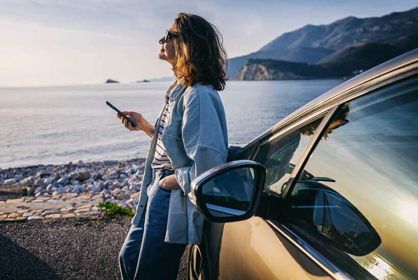 A young woman stands outside her vehicle in the South Sound region of the Pacific Northwest.